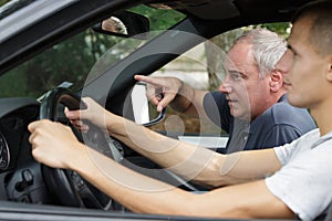 senior driving instructor giving instructions to student