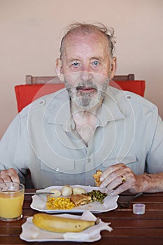 Senior eating healthy meal in residential care home