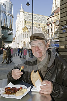 Senior eating the sausage in Vienna, Austria