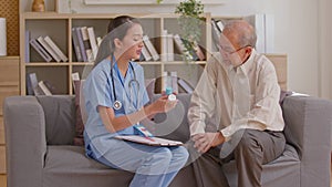Senior elder man patient talking to caring female doctor physician caregiver at nursing home in hospital holding hands explaining