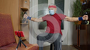 Senior elderly caucasian man making weightlifting dumbbells exercising at home during coronavirus