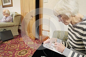 Senior elderly lady keeping mind active by doing crossword puzzle