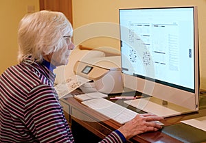 Senior elderly lady's using computer to play online puzzles