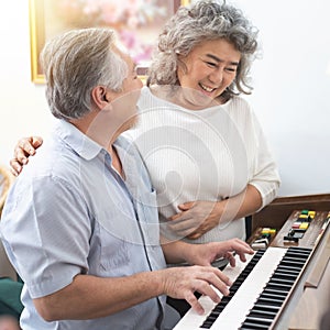 Senior elderly man plays piano in nursing home listened to by elderly woman,Retreatment elderly asian grandmother and grandfather