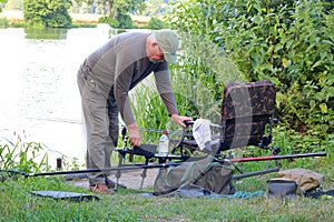 Senior or elderly man preparing to fish a lake.