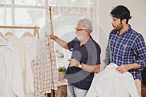 Senior elderly man shopping  buying or choosing good new clothes