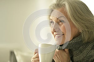 Senior elderly sick woman drinking tea at home