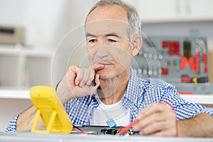 Senior electrician thinking about something