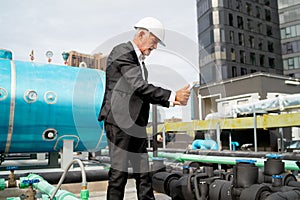 Senior engineer man use tablet to take photo or video of area on rooftop of construction site