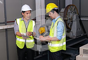 Senior engineer point to the tablet and explain to junior engineer on how to operate lift