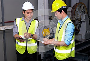 Senior engineer point to the tablet and explain to junior engineer on how to operate lift Feeling fun on work