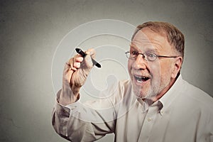 Senior excited man writing something with pen on blackboard