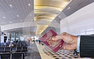 Senior executive arm holding UK Passport at airport terminal