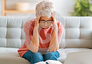Senior exhausted woman having headache photo