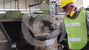 Senior factory worker teach how to use machine equipment in the factory workshop