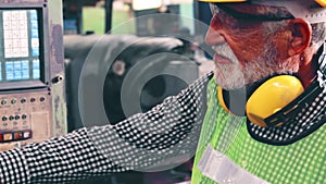 Senior factory worker teach how to use machine equipment in the factory workshop