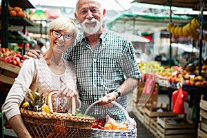 Senior family couple choosing bio food fruit and vegetable on the market during weekly shopping