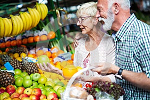 Senior family couple choosing bio food fruit and vegetable on the market during weekly shopping