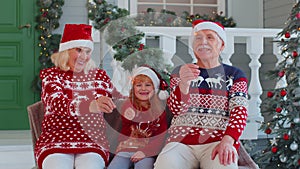 Senior family couple grandmother grandfather with granddaughter holding lit Bengal lights sparkler