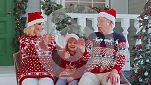 Senior family couple grandmother grandfather with granddaughter holding lit Bengal lights sparkler