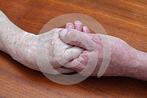 Senior family couple holding old hands, psychological support concept
