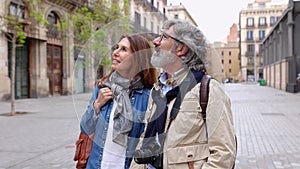 Senior family couple walking together sightseeing in Barcelona city on vacation.