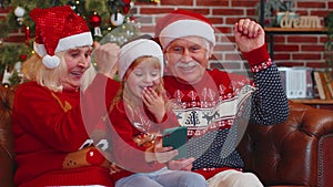 Senior family grandparents, granddaughter purchase online Christmas gifts on mobile phone, shopping