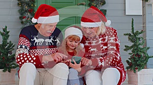 Senior family grandparents, granddaughter purchase online Christmas gifts on mobile phone, shopping