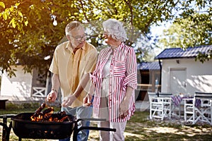 Senior family  preparing barbecue in garden together
