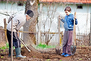 Senior farmer with grandson in the garden