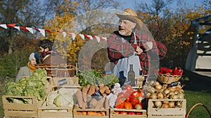 Senior farmer stands at the stall at farmers market