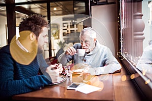 Senior father and his young son in a cafe.