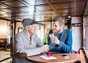 Senior father and his young son in a pub.