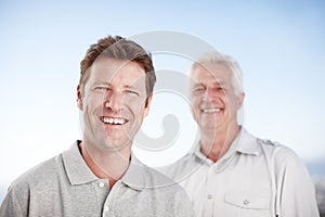 Senior father, man and outdoor for portrait with smile, care and bonding on vacation with summer sky. Elderly dad, son