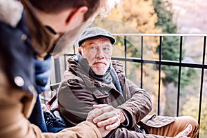 Senior father in wheelchair and young son on a walk.