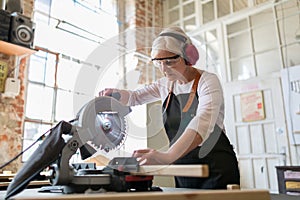 Senior female carpenter working with a circular saw