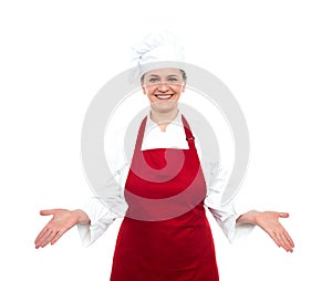 Senior female chef standing with open palms