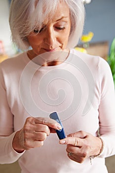 Senior Female Diabetic Checking Blood Sugar Levels photo