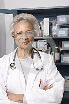 Senior Female Doctor With Arms Crossed In Clinic