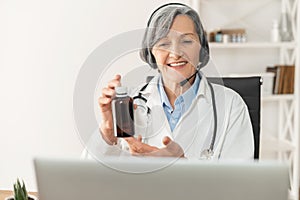 Senior female doctor demonstrating a bottle