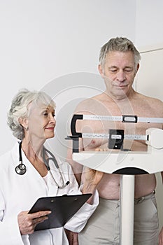 Senior Female Doctor Measuring patient's Weight