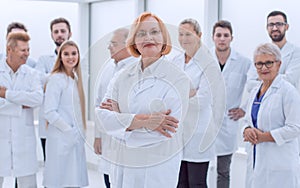 senior female doctor standing in front of her colleagues.