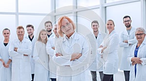 senior female doctor standing in front of her colleagues.