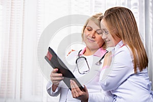 Senior female doctor talking to a pharmaceutical sales representative. Photo indoor medical office, side space for your ad