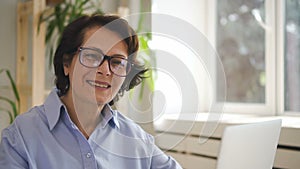 Senior female editor in glasses and blue shirt smiling