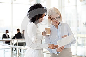 Senior female executive discussing report with young mixed race