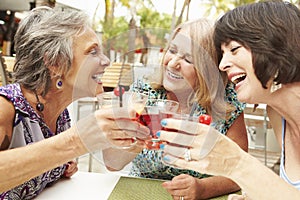 Senior Female Friends Enjoying Cocktails In Bar Together