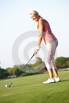 Senior Female Golfer Teeing Off