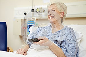 Senior Female Patient Watching TV In Hospital Bed