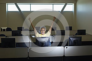 Senior Female Professor Celebrating Victory In Computer Classroom